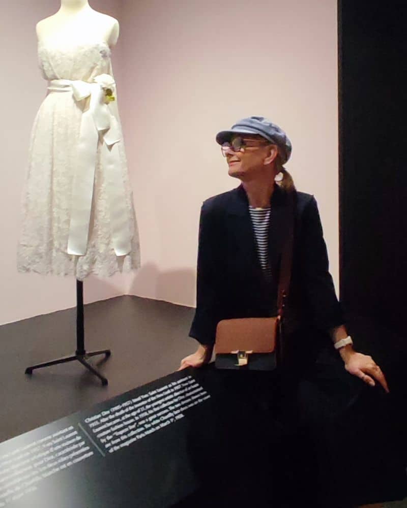 Eine Frau sitzt vor einem Kleid von Yves Saint Laurent
