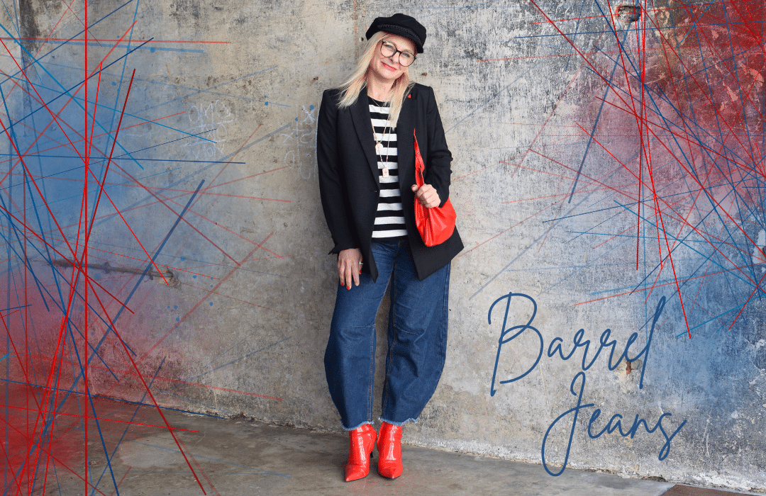Dunkelblaue Barrel Jeans kombiniert mit Streifenshirt, schwarzem Blazer und roten Accessoires – modischer Streetstyle für Frauen.