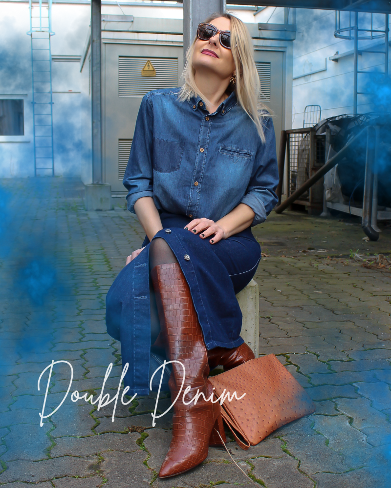 Frau trägt einen Double-Denim Look aus dunkelblauem, langen, engen Jeansrock und einem langärmligen Jeanshemd.