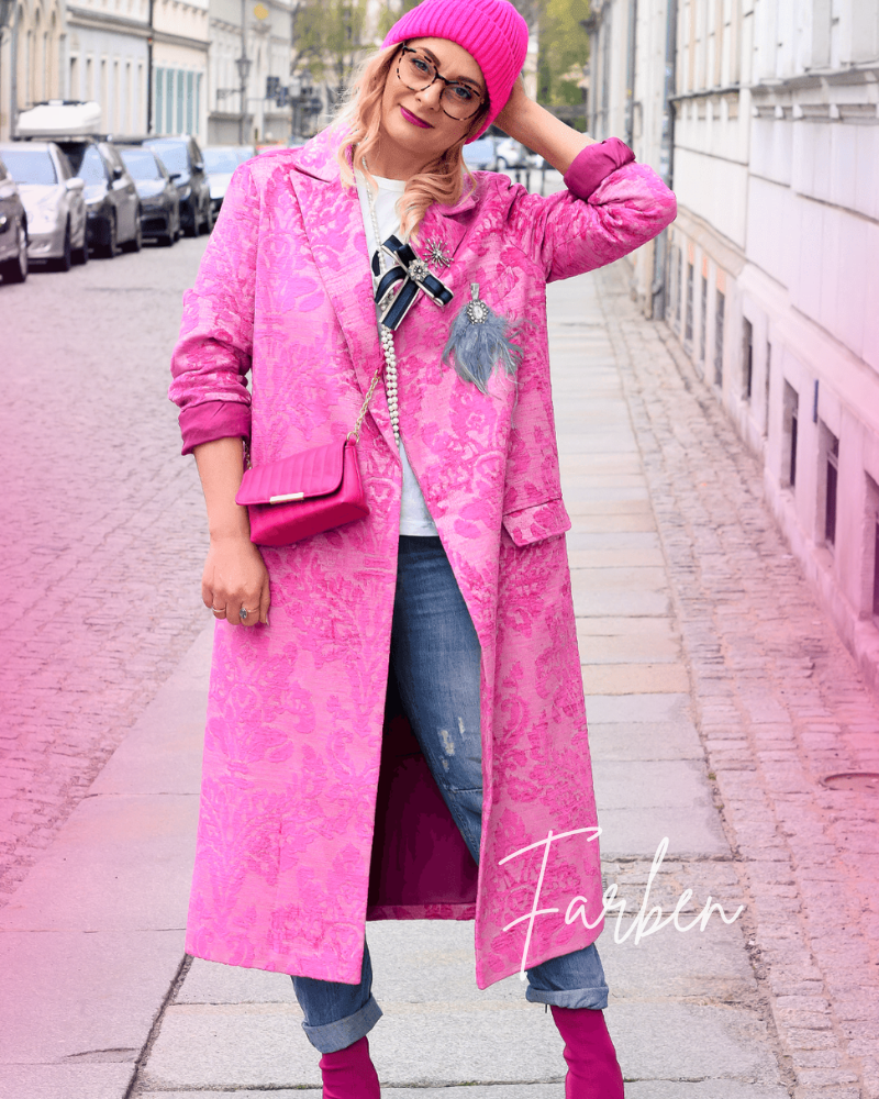Frau trägt Outfit aus Jeans und Mantel in Pink und pinkfarbenen Accessoires